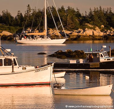Aluminum expedition sailboat Morgan's Cloud is illuminated by the evening sun while lying on a rented mooring in the outer harbour at Matinicus, the furthest offshore of Maine's 15 year-round inhabited islands
