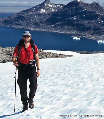 Ted, crew member on aluminum sailboat Morgan's Cloud, crosses a snowfield on the small mountain above Lindenow Fjord, Southeast Greenland