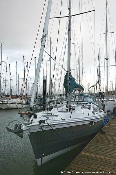 An OVNI 435 aluminum sailboat with a roller furling yankee, coupled with a hanked on staysail on a detachable stay. The mainsail is fully battened, using Harken cars and mast track. Single reefing lines lead aft to the cockpit handled by a power driven winch