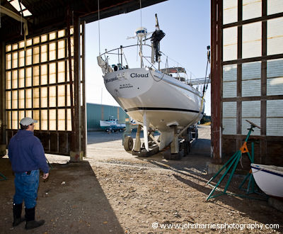 Aluminum expedition sailboat Morgan's Cloud on a Brunell trailer, backing into her winter shed