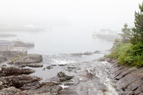 Looking along waterfall to sailboat alongside wharf in Grand Bruit, Newfoundland