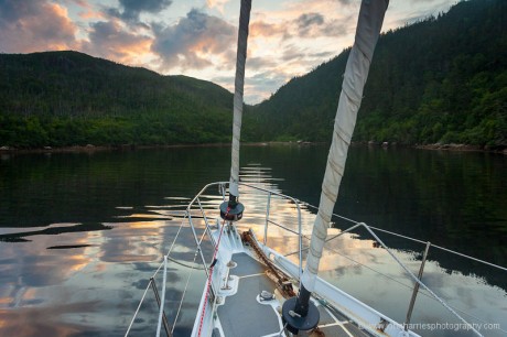 Anchorage at Doctor Harbour, Newfoundland at sunset over bow of sailboat Morgan's Cloud